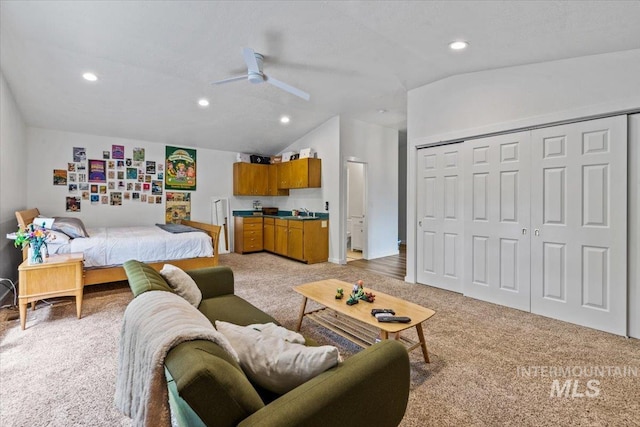 bedroom featuring vaulted ceiling, light colored carpet, ceiling fan, and a closet