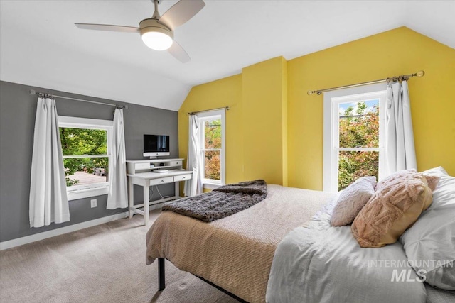 carpeted bedroom with vaulted ceiling and multiple windows