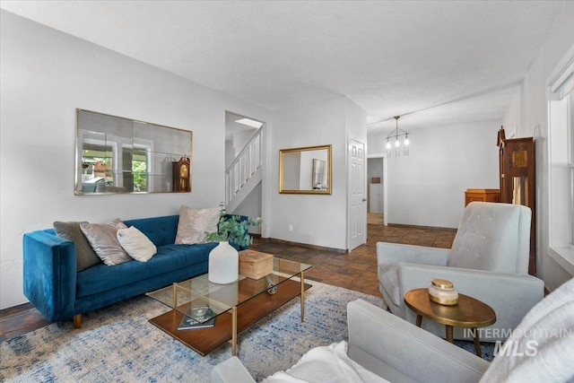 living room featuring a notable chandelier and a textured ceiling