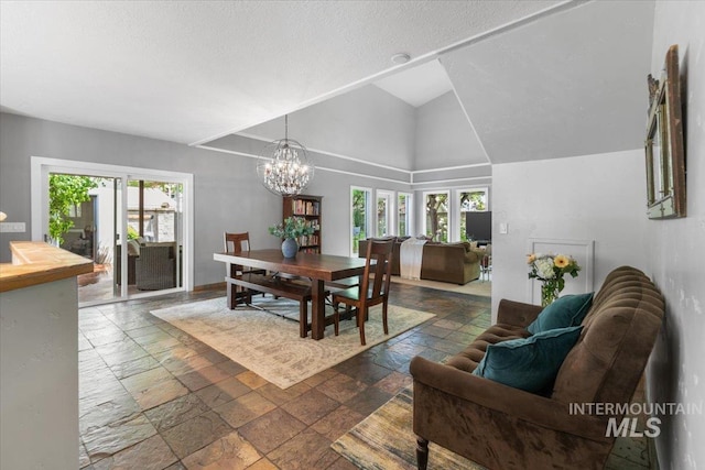 dining area featuring plenty of natural light, high vaulted ceiling, a textured ceiling, and a notable chandelier