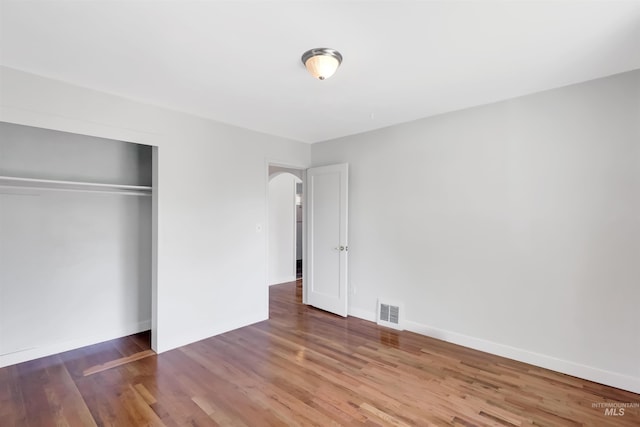 116 6th Ave E, Jerome, ID 83338 - unfurnished bedroom featuring arched walkways, wood finished floors, a closet, and baseboards