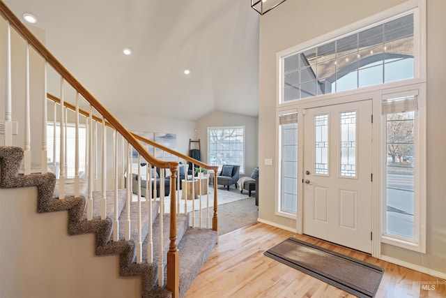 entryway with recessed lighting, vaulted ceiling, stairway, and wood finished floors