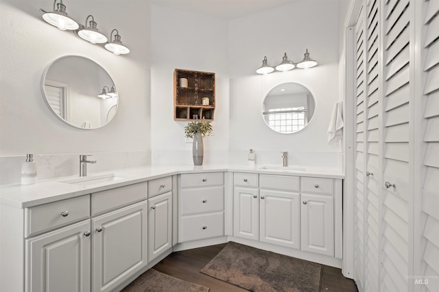 full bathroom featuring double vanity, a sink, and wood finished floors