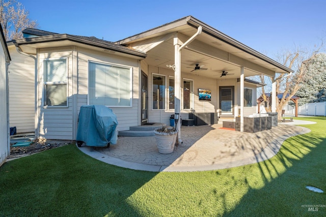 rear view of house featuring ceiling fan, a yard, a patio, and fence