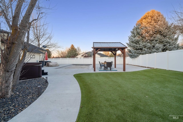 view of yard with a patio area, a hot tub, a fenced backyard, and a gazebo