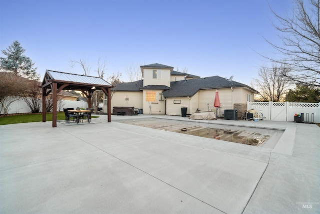 view of front of house featuring a gazebo, central AC unit, a patio, and a fenced backyard