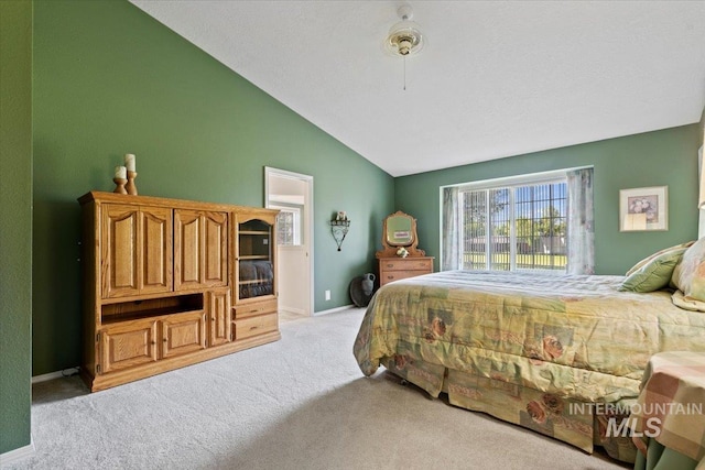 bedroom with light carpet, lofted ceiling, and baseboards