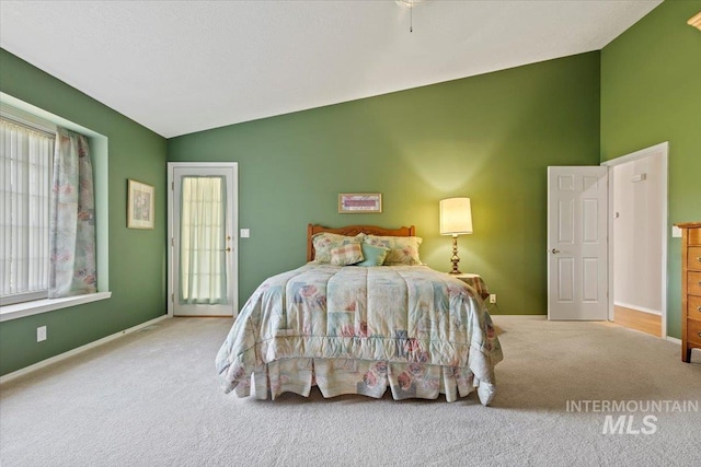 carpeted bedroom featuring lofted ceiling and baseboards