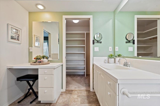 bathroom featuring a walk in closet and vanity