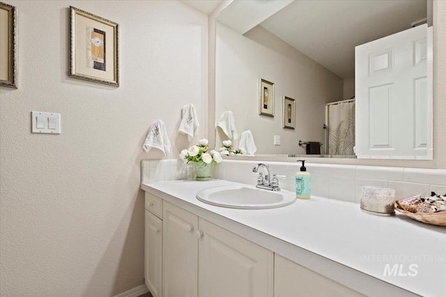 bathroom featuring vanity and backsplash