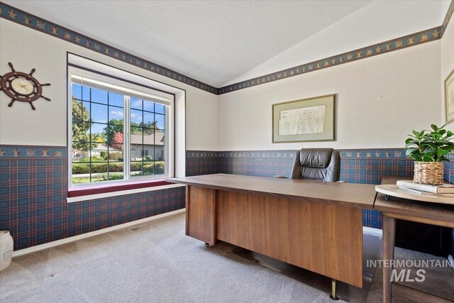 office area featuring vaulted ceiling, a wainscoted wall, carpet, wallpapered walls, and a textured ceiling