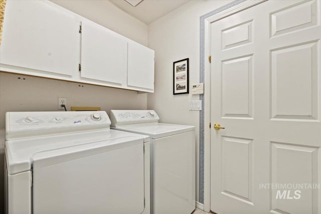 clothes washing area featuring washer and dryer and cabinet space