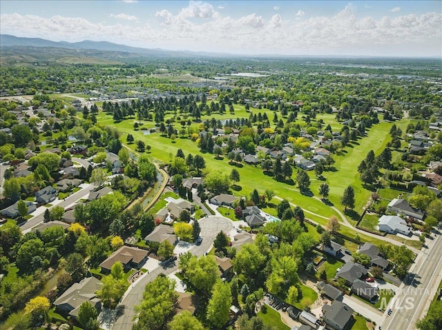 aerial perspective of suburban area with a golf course and a mountain backdrop