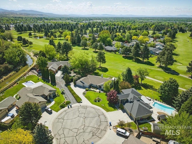 aerial perspective of suburban area featuring a golf course and a pool area