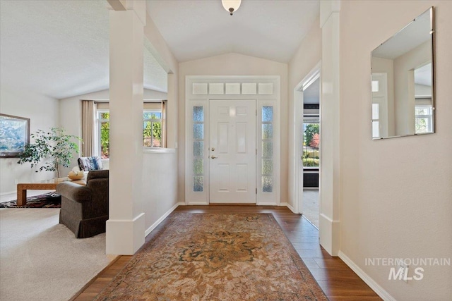 foyer entrance featuring vaulted ceiling, wood finished floors, and baseboards