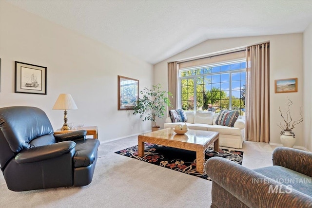 carpeted living area featuring vaulted ceiling and baseboards