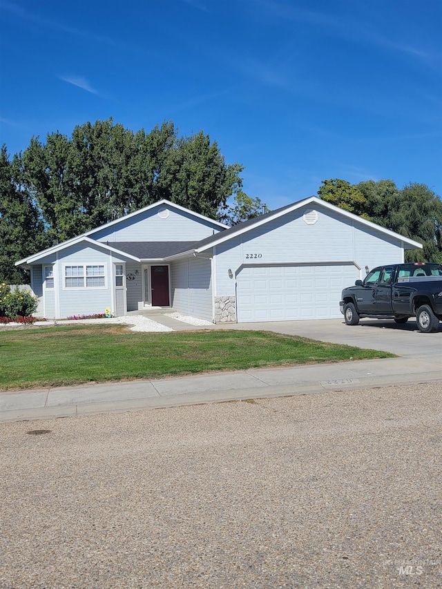 single story home with a garage and a front lawn