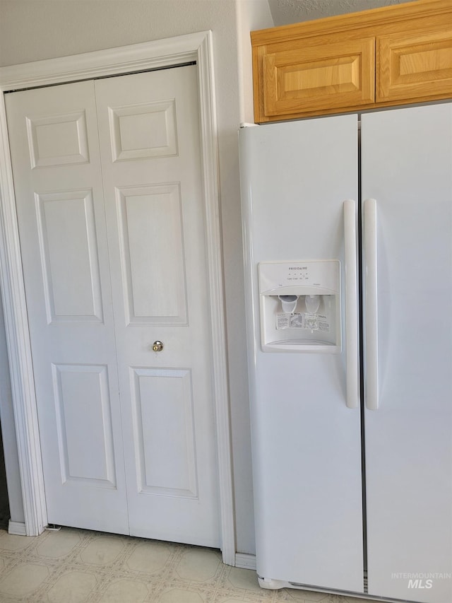 kitchen featuring white refrigerator with ice dispenser