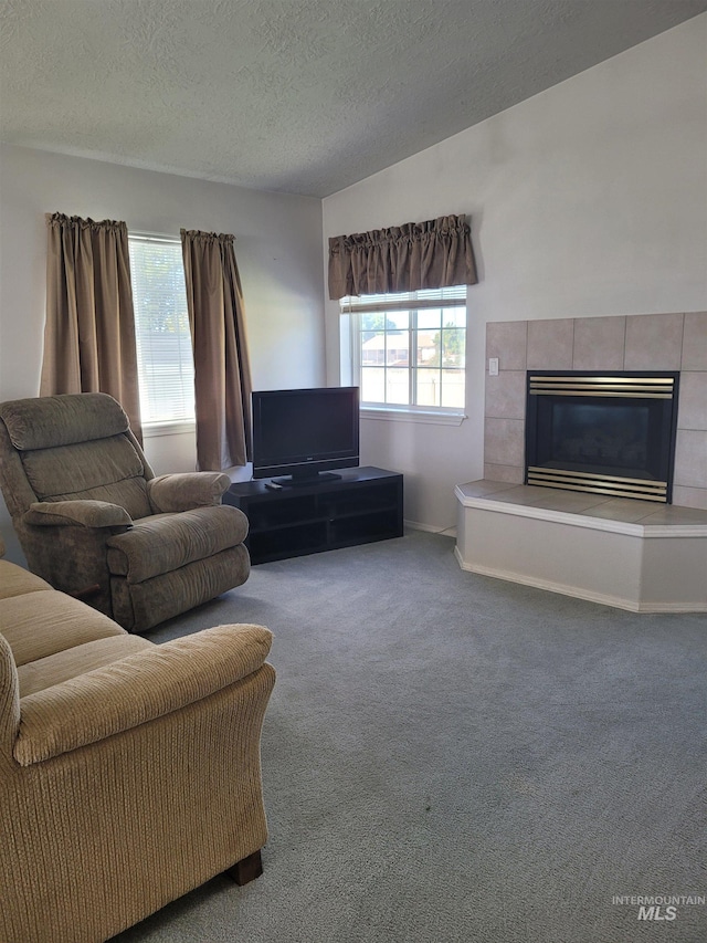 unfurnished living room featuring a textured ceiling, a fireplace, and carpet flooring