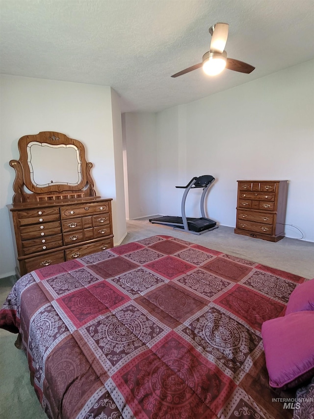 bedroom featuring ceiling fan, carpet flooring, and a textured ceiling