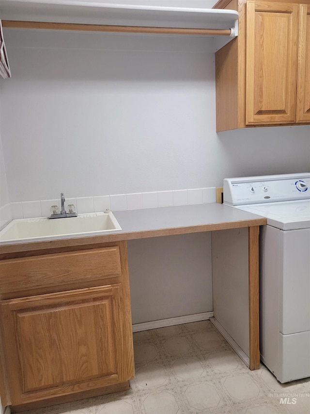 laundry area with cabinets, sink, and washer / dryer