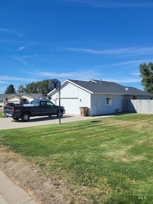 view of side of property with a yard and a garage