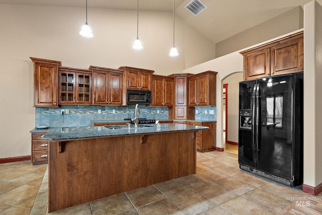 kitchen with visible vents, arched walkways, a sink, black appliances, and tasteful backsplash