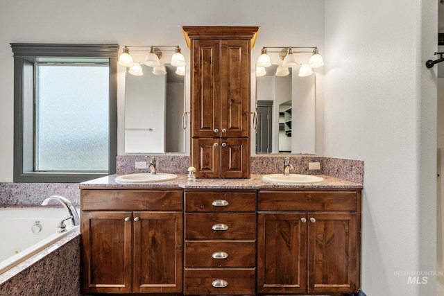 full bathroom with double vanity, a jetted tub, and a sink