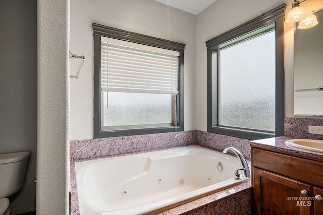 full bath featuring vanity, toilet, and a whirlpool tub