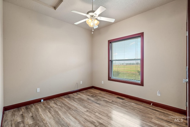 unfurnished room featuring visible vents, baseboards, light wood-style floors, a textured ceiling, and a ceiling fan