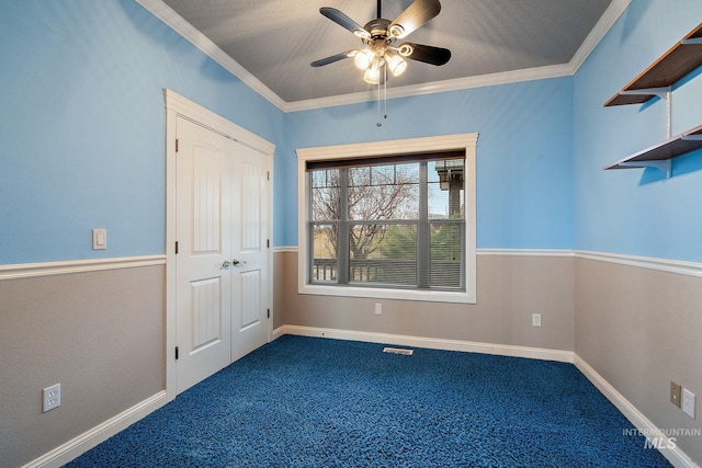 unfurnished bedroom featuring a closet, baseboards, crown molding, and carpet