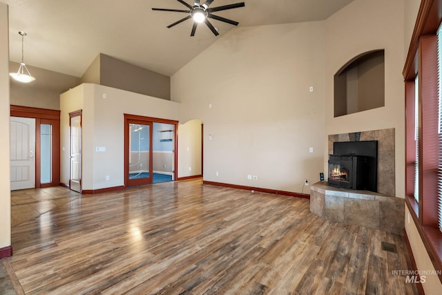 unfurnished living room with visible vents, high vaulted ceiling, baseboards, and wood finished floors