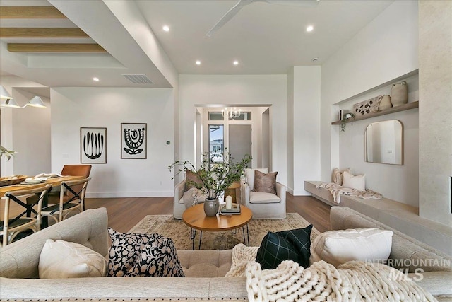 living room featuring beamed ceiling and dark wood-type flooring