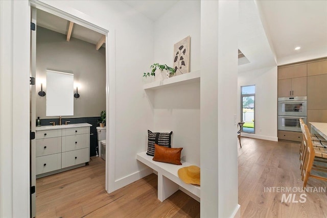 interior space featuring beam ceiling and light hardwood / wood-style floors