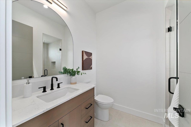 bathroom with vanity, toilet, and a shower with door