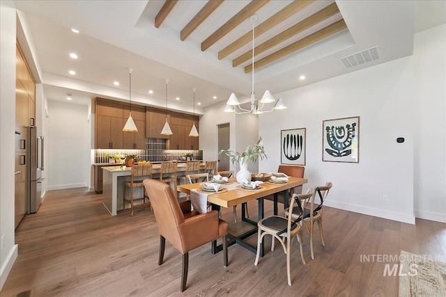 dining area featuring hardwood / wood-style floors, a chandelier, and a tray ceiling