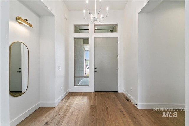 foyer entrance featuring a notable chandelier and light hardwood / wood-style floors