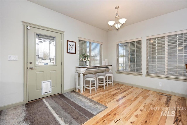 foyer entrance featuring hardwood / wood-style floors and a chandelier