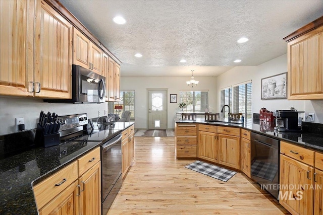 kitchen with a textured ceiling, a notable chandelier, black appliances, light hardwood / wood-style floors, and sink