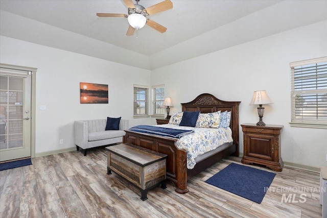 bedroom featuring lofted ceiling, multiple windows, ceiling fan, and hardwood / wood-style flooring