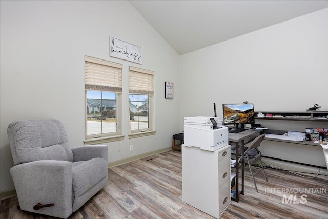 home office with vaulted ceiling and light hardwood / wood-style floors