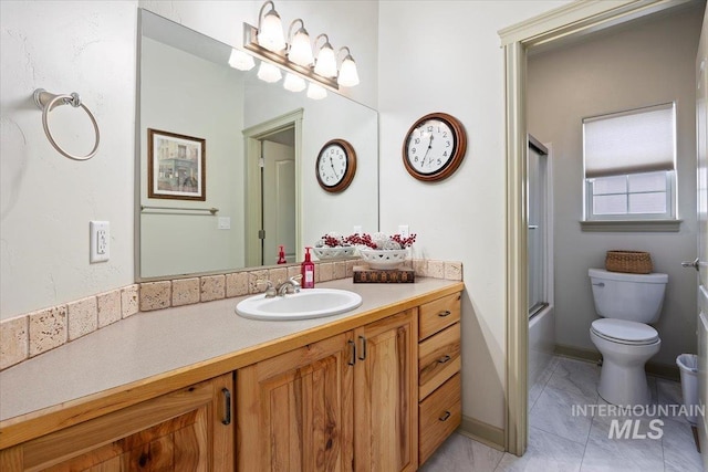 full bathroom featuring enclosed tub / shower combo, vanity, and toilet