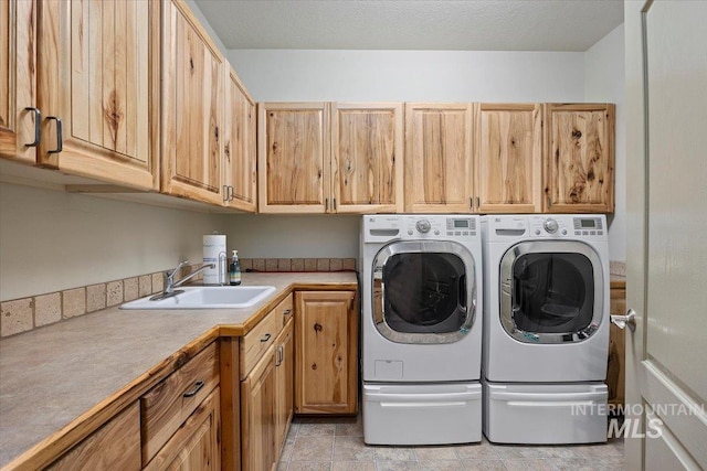 washroom featuring sink, cabinets, and independent washer and dryer