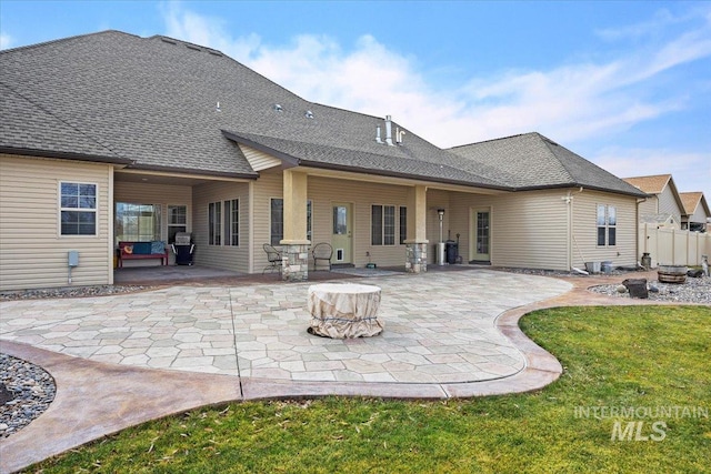 rear view of property featuring an outdoor fire pit, a patio, and a yard