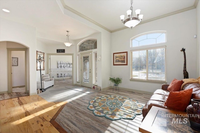 living room with a notable chandelier, light wood-type flooring, and crown molding