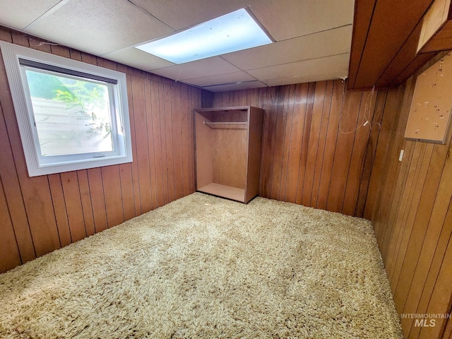 spare room with wooden walls and a paneled ceiling