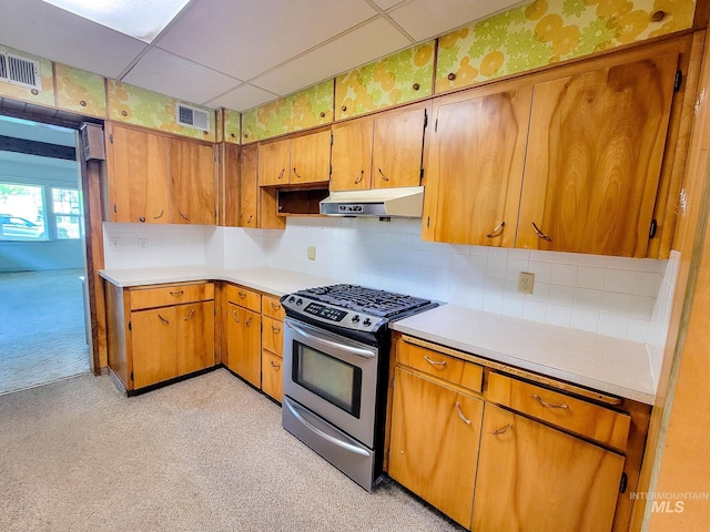 kitchen with decorative backsplash, a drop ceiling, light colored carpet, and gas range