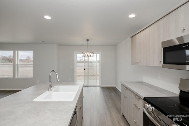 kitchen featuring recessed lighting, stainless steel appliances, light countertops, and a sink