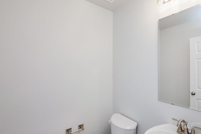 half bath featuring toilet and a sink