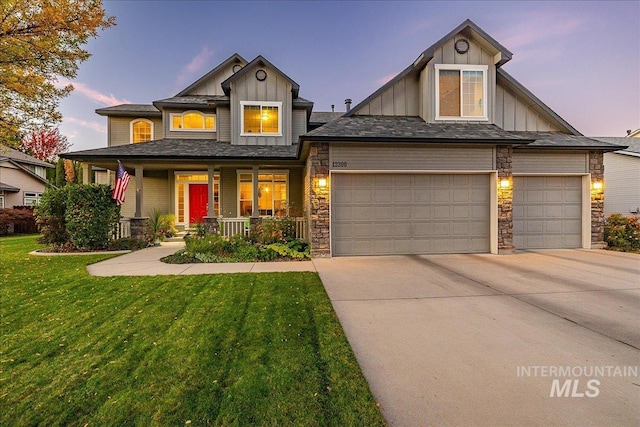 view of front of home featuring covered porch, a garage, and a lawn